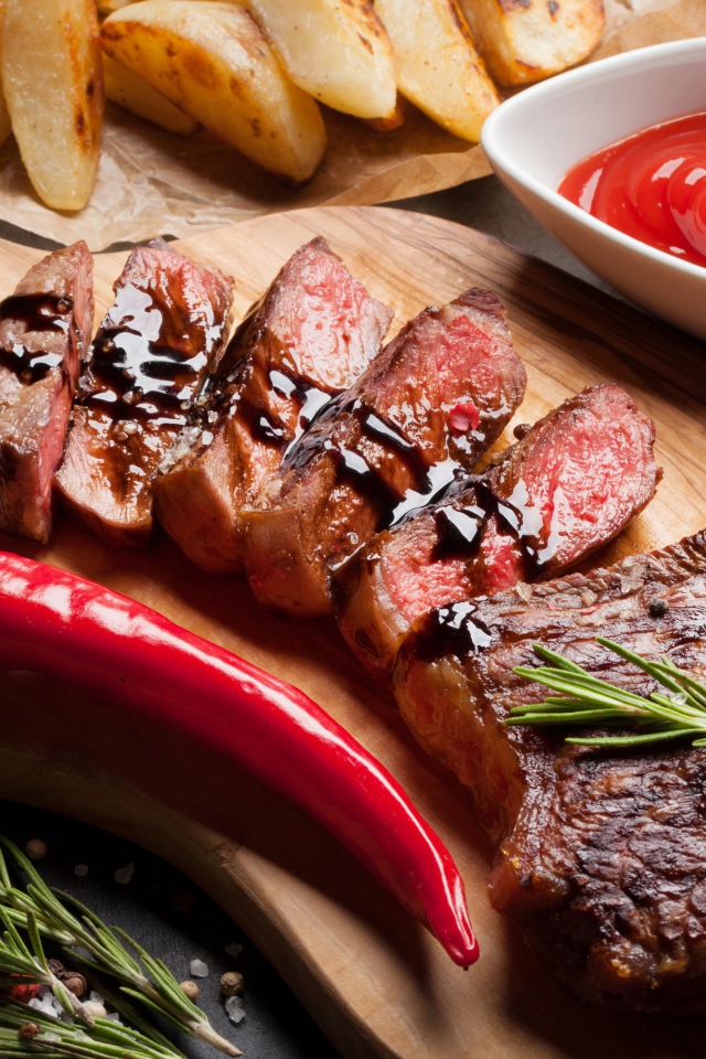 Аппетитный сочный стейк с соусом, красным перцем и специями на столе