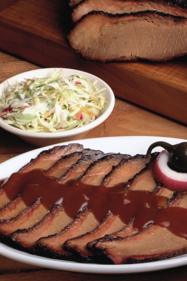 Аппетитные кусочки мяса барбекю на столе с овощами