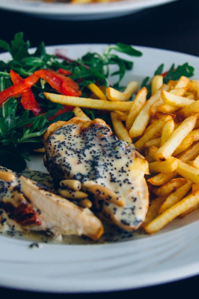 Курица с картофелем фри и салатом на большой белой тарелке