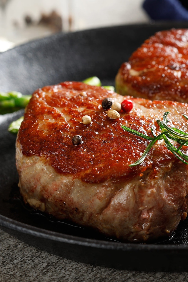 Два аппетитных сочных куска мяса с помидорами и розмарином