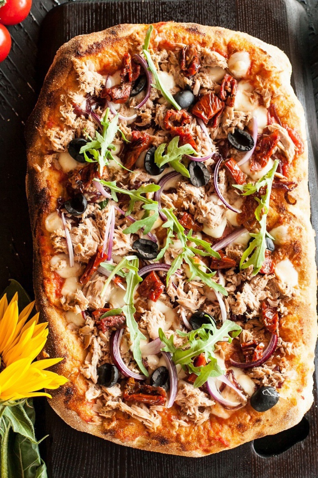 Жареная пицца с мясом на столе с желтым цветком подсолнуха