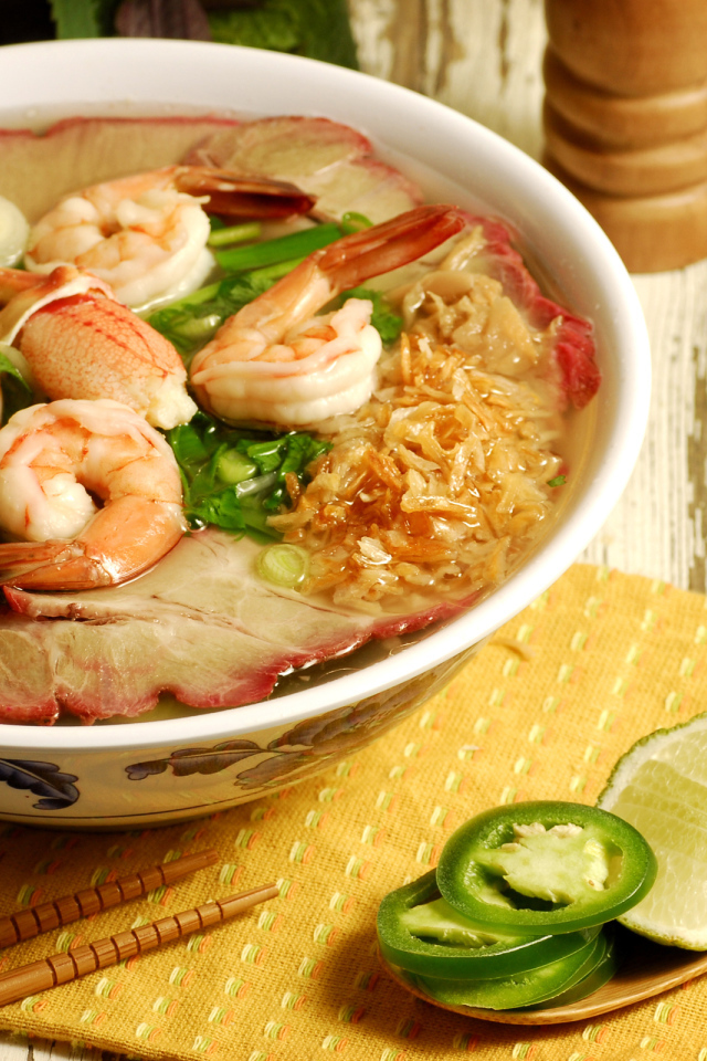 Тарелка супа с креветками и морепродуктами на столе