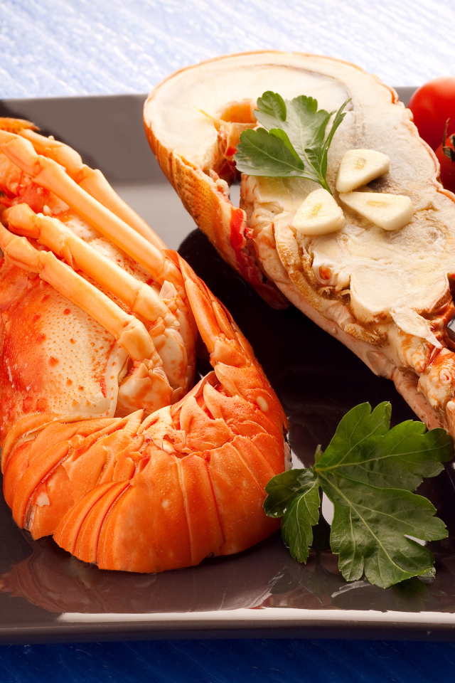 Аппетитный вареный омар на тарелке с помидорами 