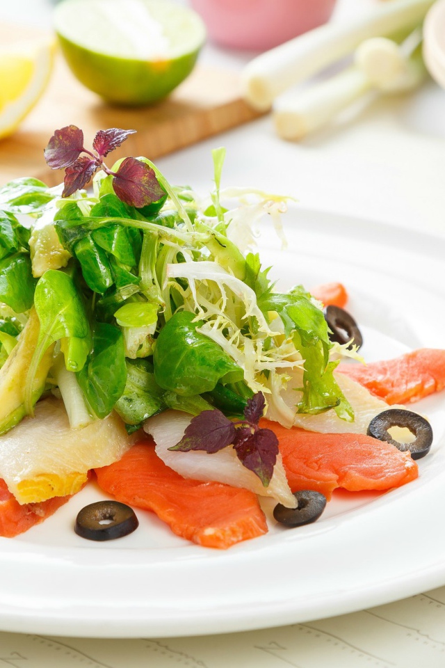 Аппетитный салат с морепродуктами на белой тарелке 