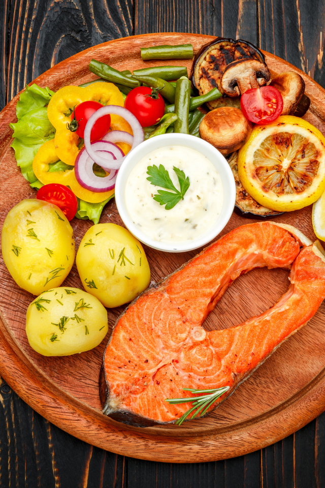 Жареный кусок рыбы с овощами и соусом