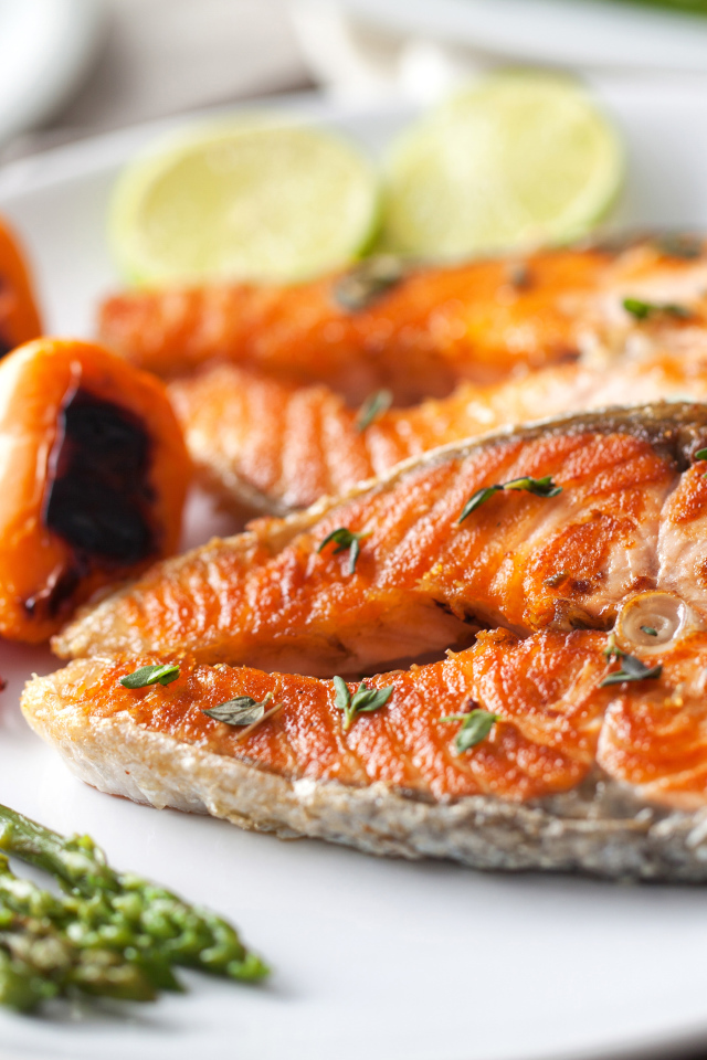 Два кусочка жареной красной рыбы с овощами 