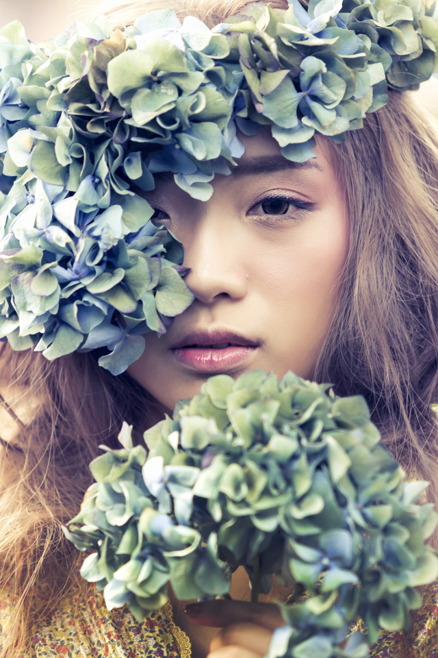 Молодая девушка азиатка с венком из цветов на голове