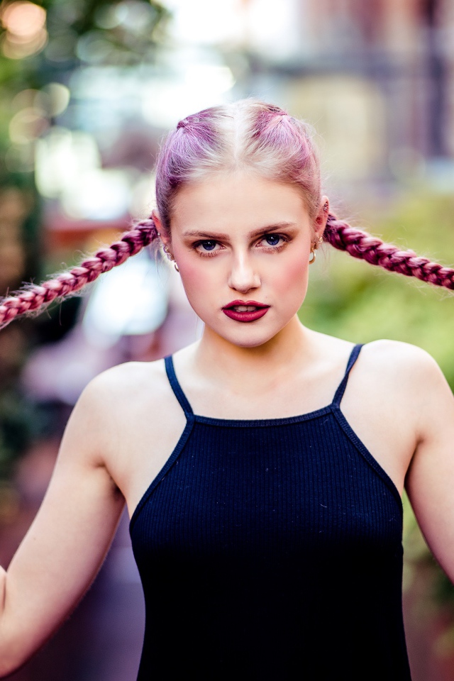 Молодая девушка с розовыми косами на голове