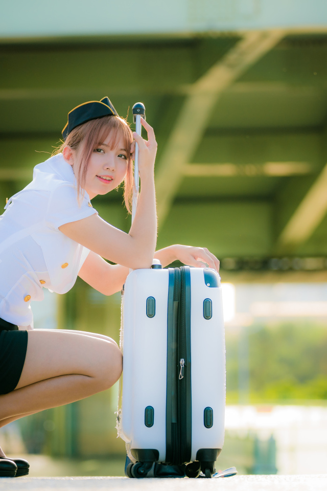 Девушка азиатка стюардесса с чемоданом