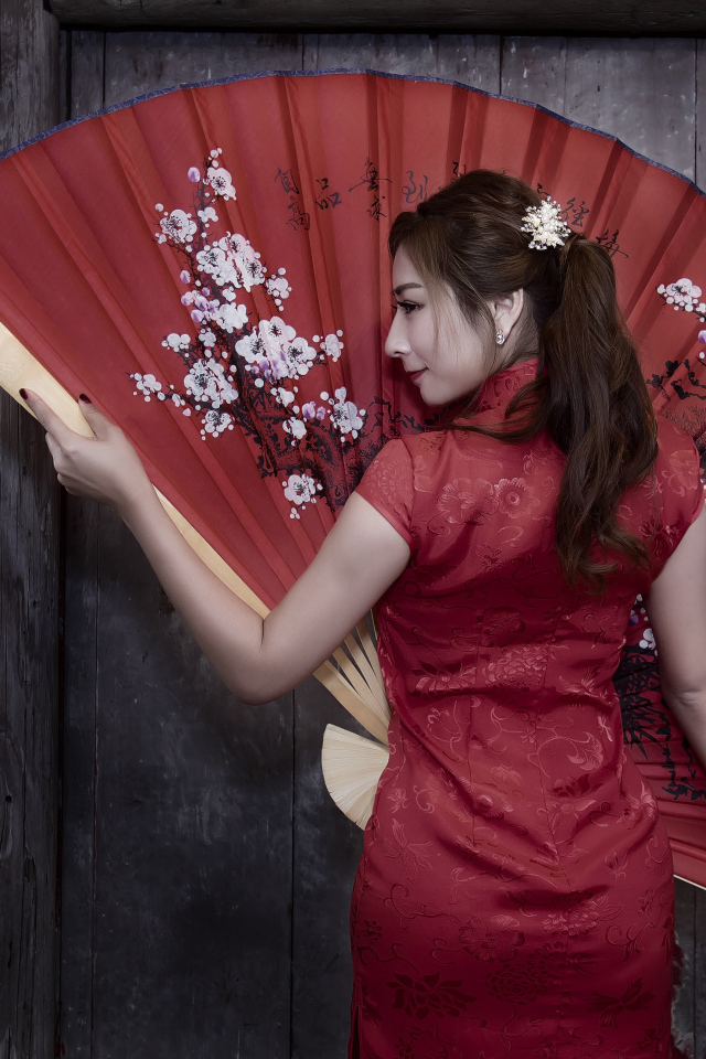 Красивая девушка азиатка в красном платье с большим веером
