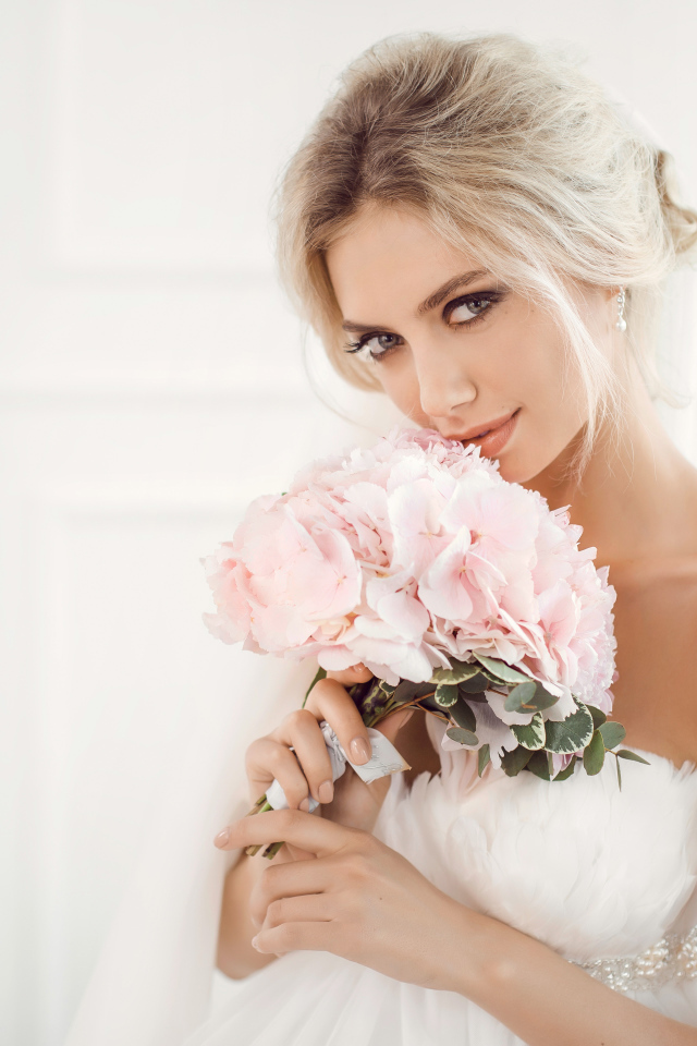 Красивая блондинка невеста с букетом розовых цветов в руках