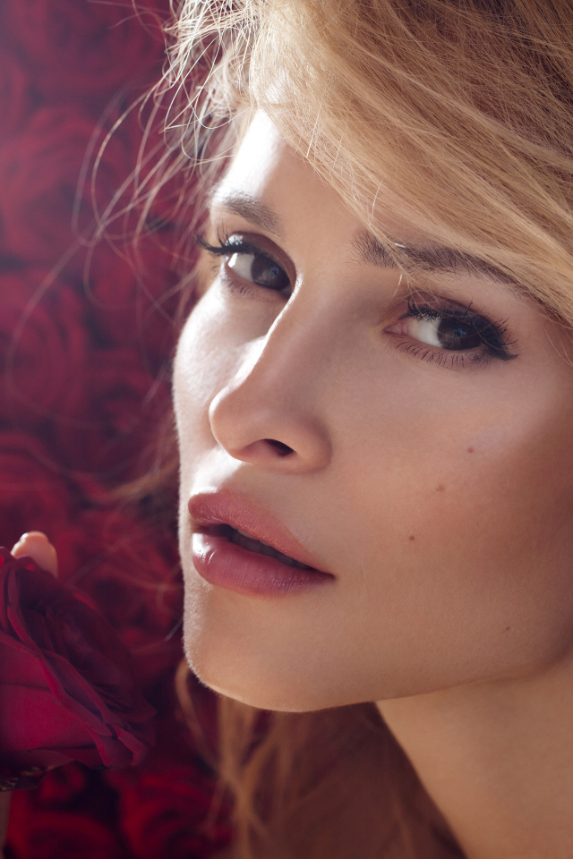 Красивая девушка блондинка с красной розой в руке