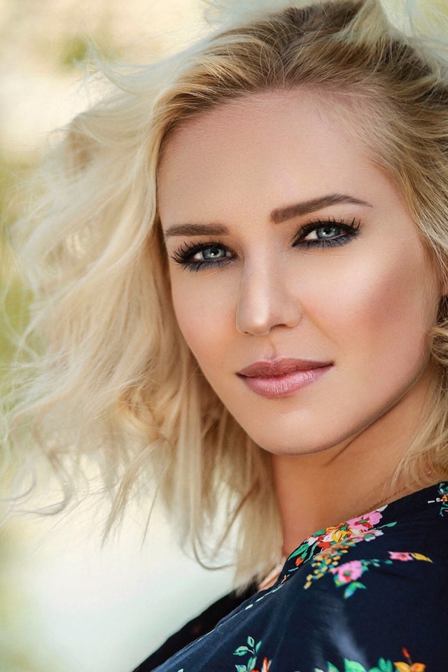 Красивая блондинка с голубыми глазами у дерева 