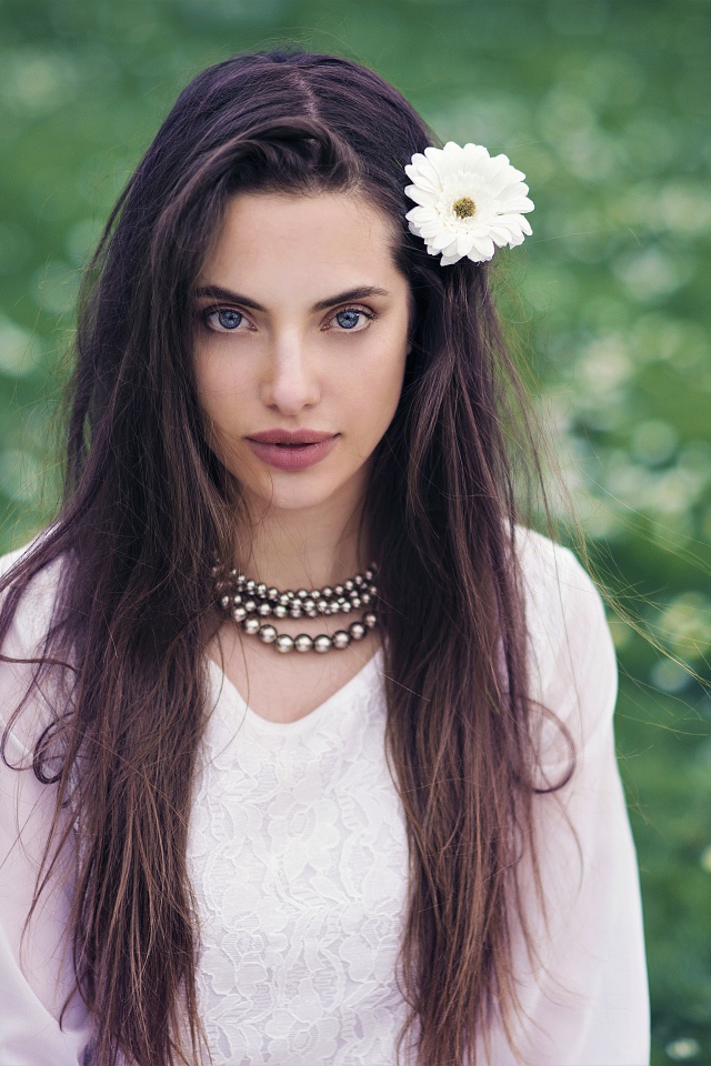 Красивая голубоглазая брюнетка с белым цветком в волосах