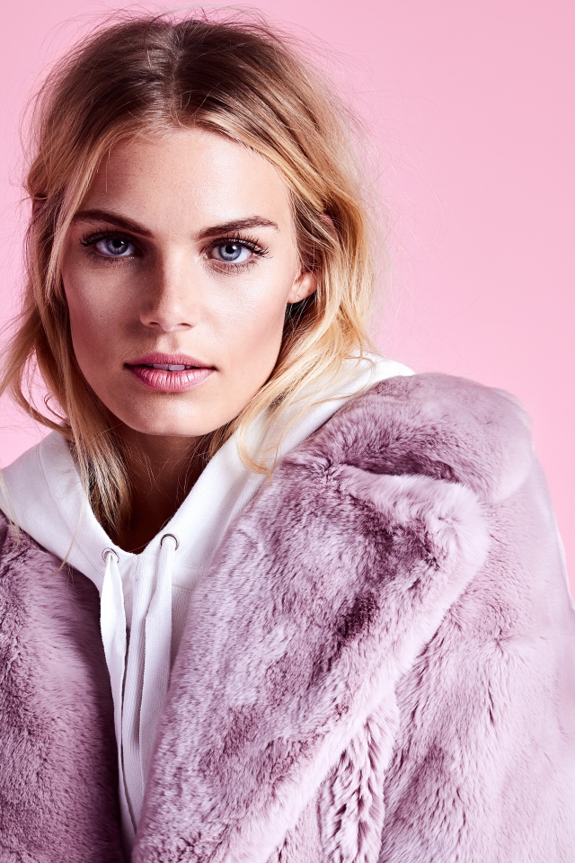 Красивая голубоглазая девушка в шубе на розовом фоне