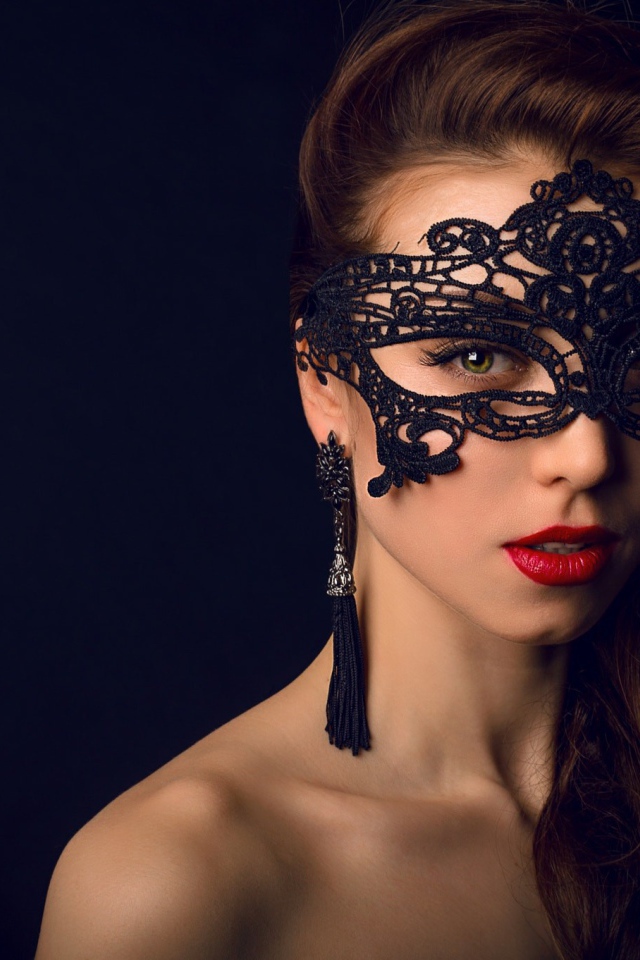 Красивая брюнетка с черной маской на лице 