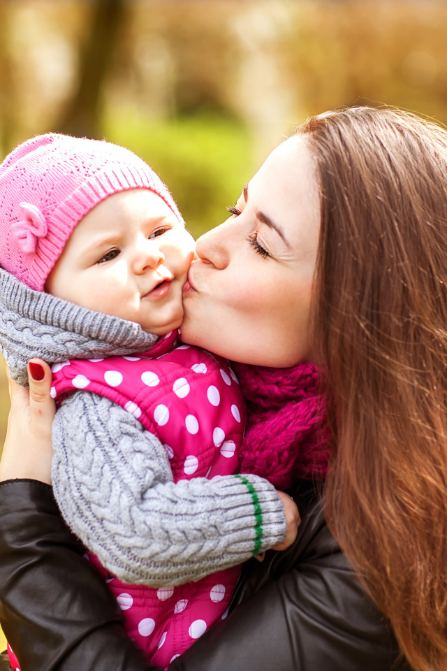 Красивая девушка держит в руках маленького ребенка