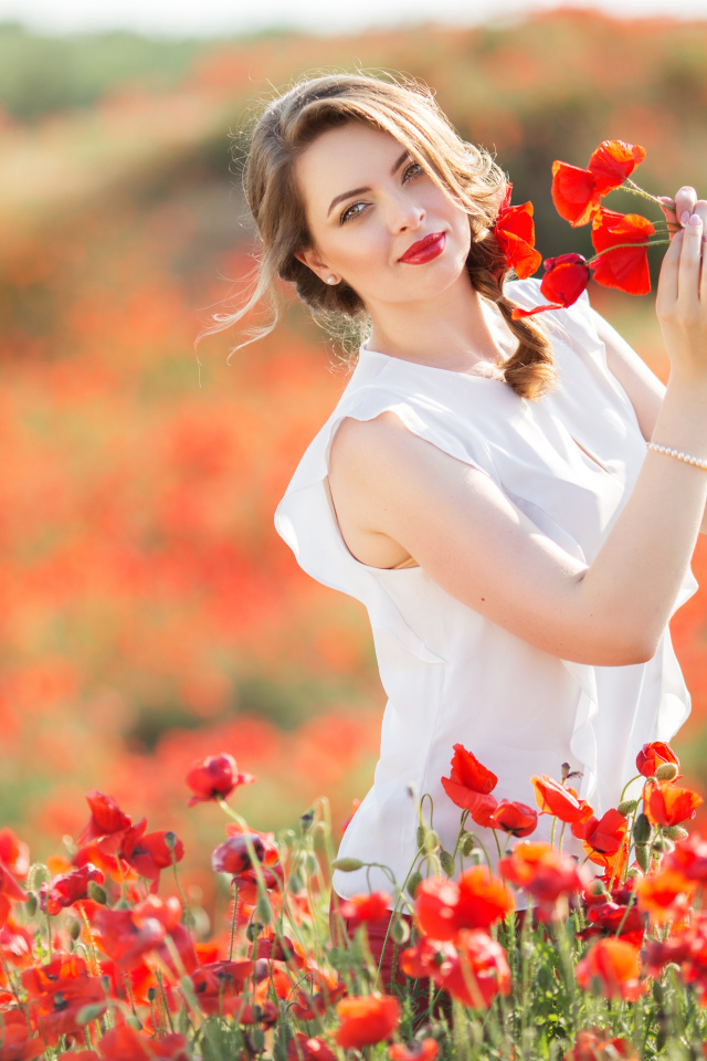 Красивая девушка в белом платье с букетом маков в руках
