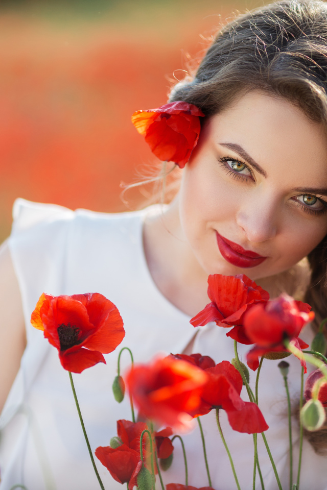 Красивая девушка с выразительным взглядом на поле с красными маками