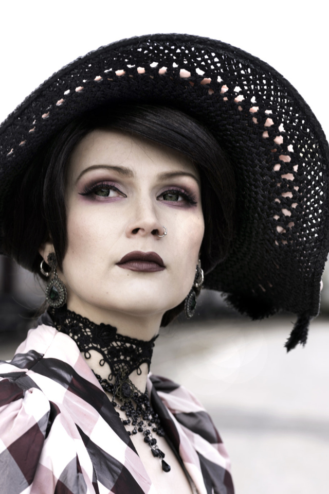 Красивая зеленоглазая девушка в большой черной шляпе