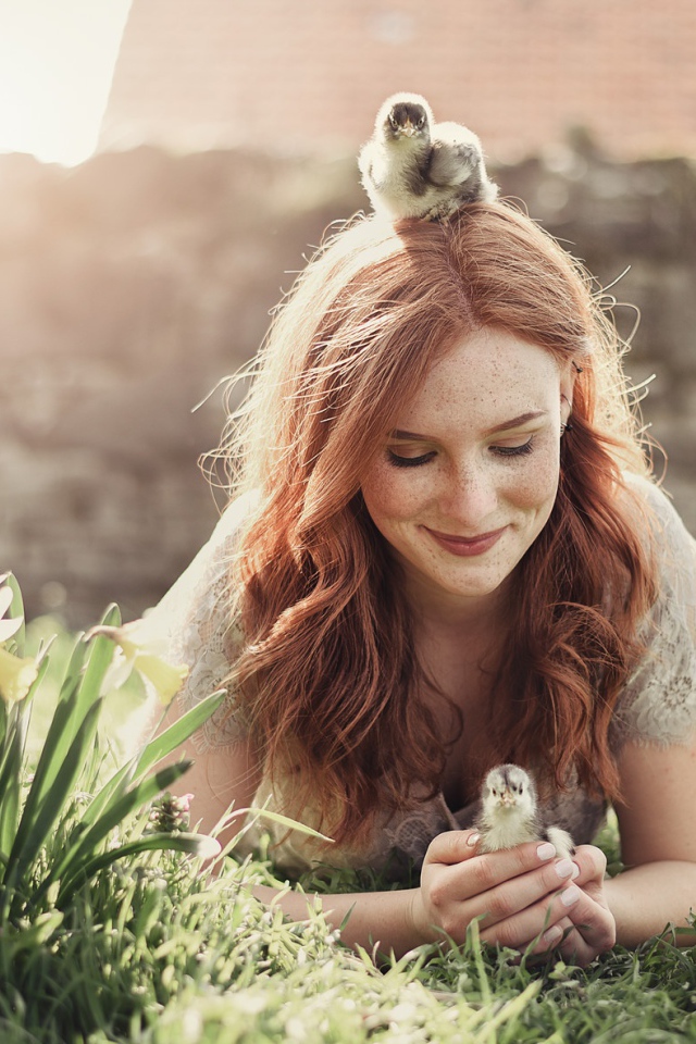 Красивая рыжеволосая девушка с маленькими цыплятами  