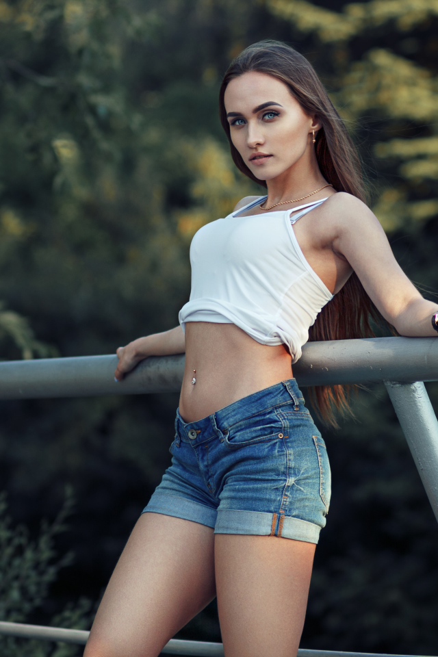 Красивая стройная девушка в джинсовых шортах