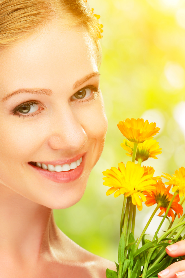 Красивая улыбающаяся девушка с цветами календулы в волосах