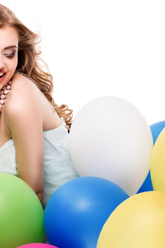 Красивая улыбающаяся девушка с разноцветными шариками на белом фоне
