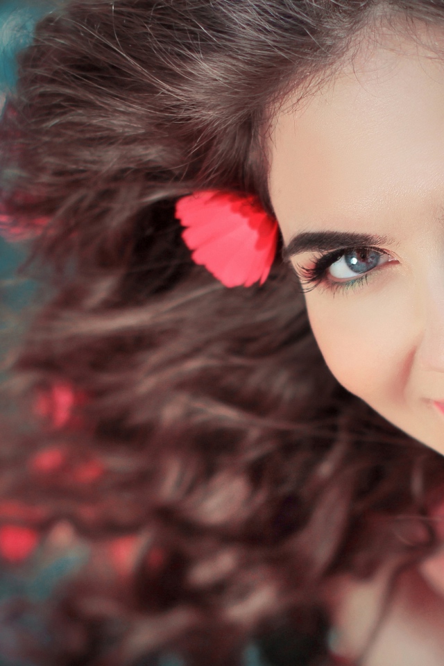 Красивая улыбающаяся девушка с розовыми цветами в волосах 