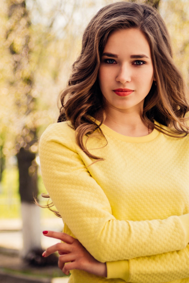 Красивая молодая голубоглазая девушка в желтом свитере