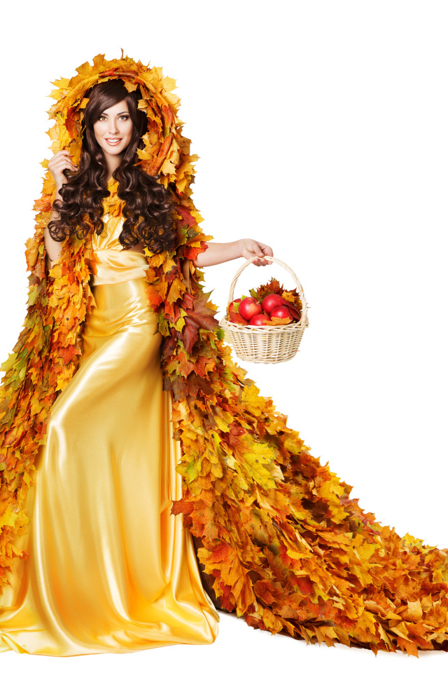 Красивая молодая девушка в плаще из желтых листьев с корзиной в руке