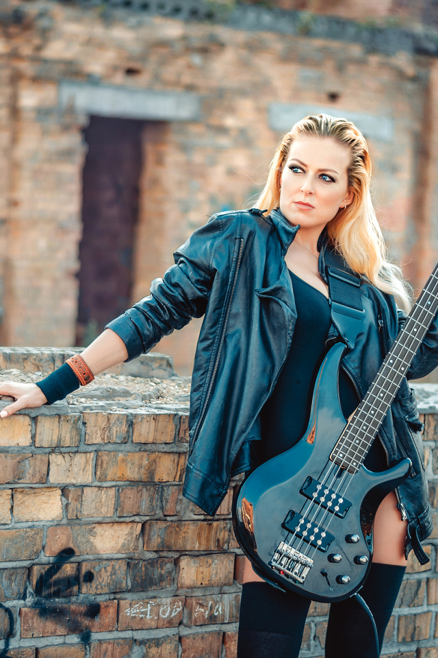 Блондинка в кожаной куртке с электрогитарой в руках