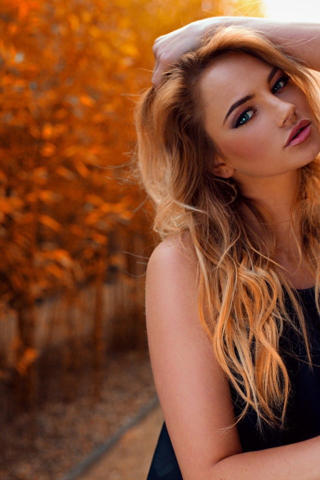 Голубоглазая девушка блондинка у стены 