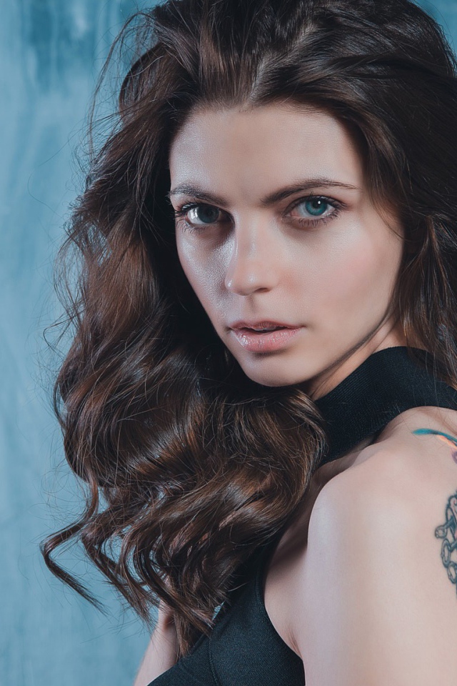 Голубоглазая девушка с татуировкой на спине 