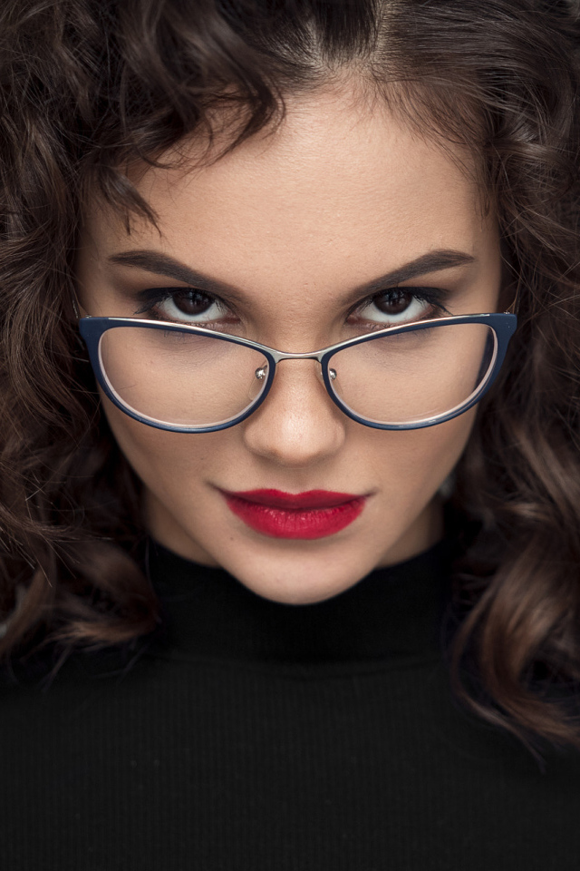 Брюнетка с красными губами с очками на лице