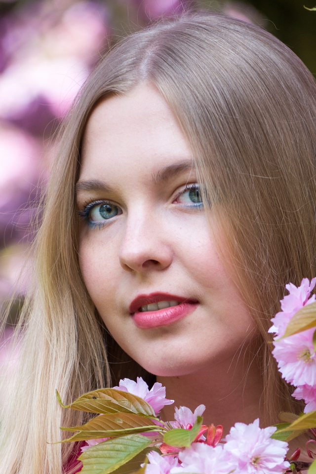 Милая голубоглазая девушка с розовыми цветами 