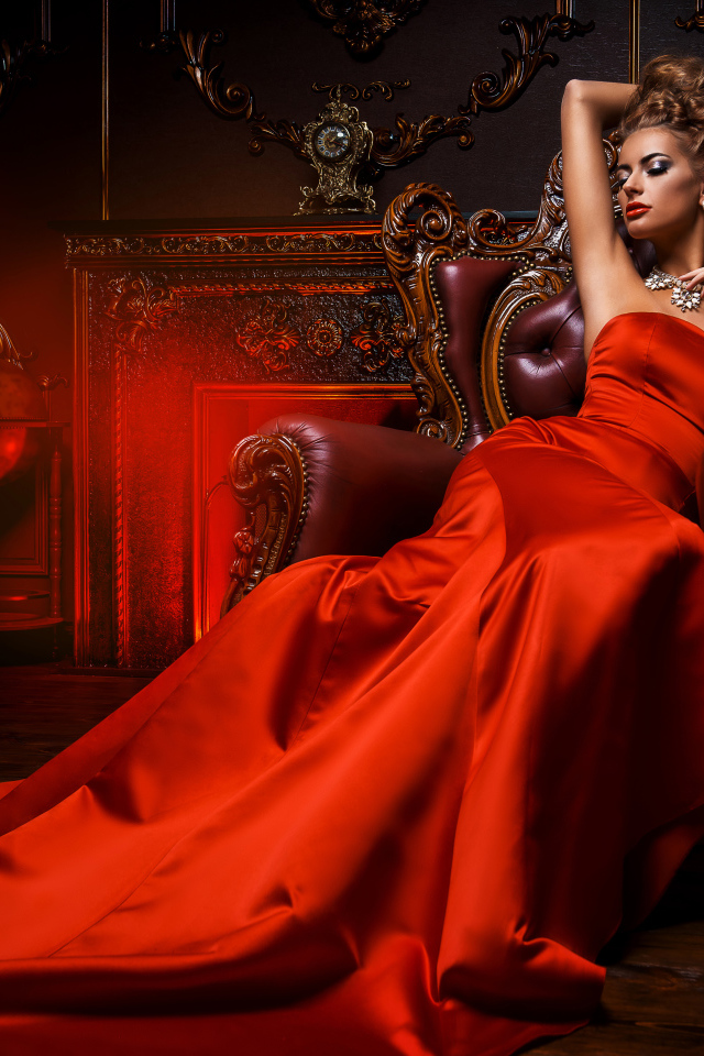Девушка в красивом красном платье в кресле 