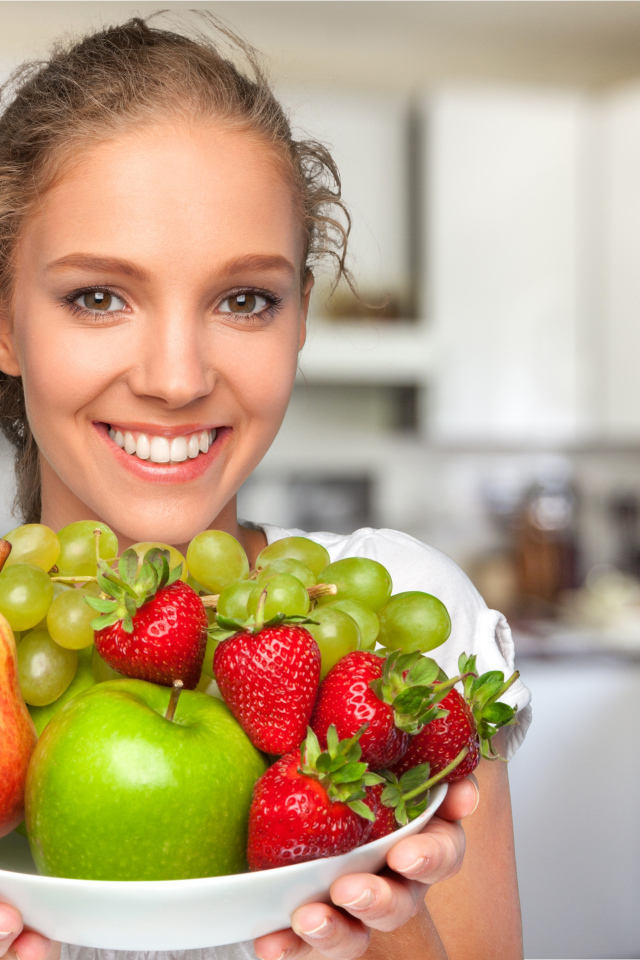 Улыбающаяся девушка со свежими фруктами 