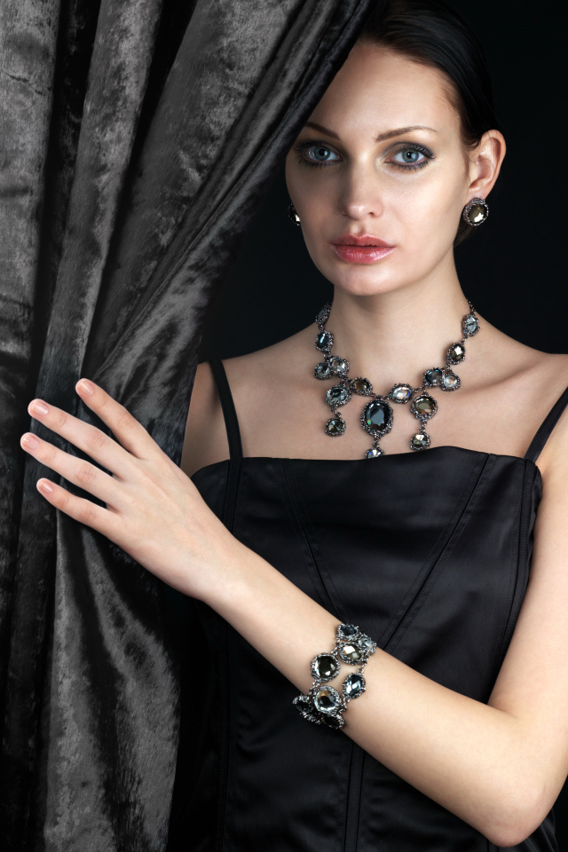 Эффектная девушка в черном платье и дорогих украшениях