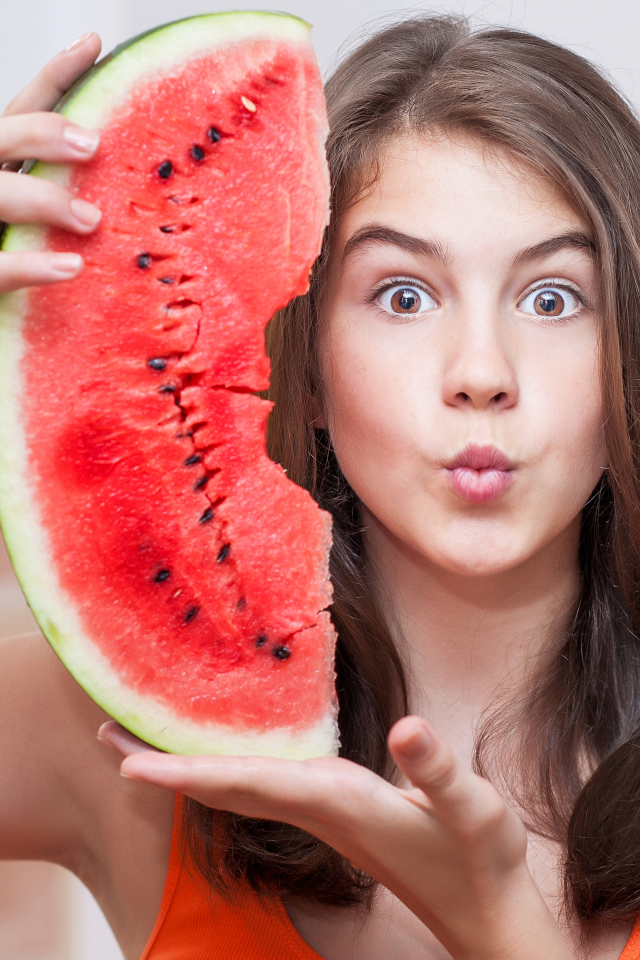 Девушка держит в руках скибку арбуза