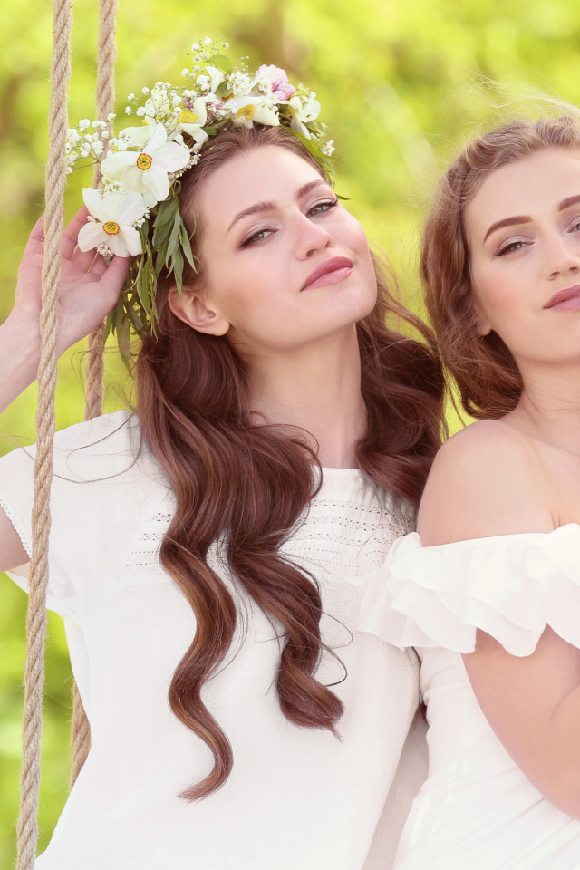 Две красивые длинноволосые девушки шатенки на качели