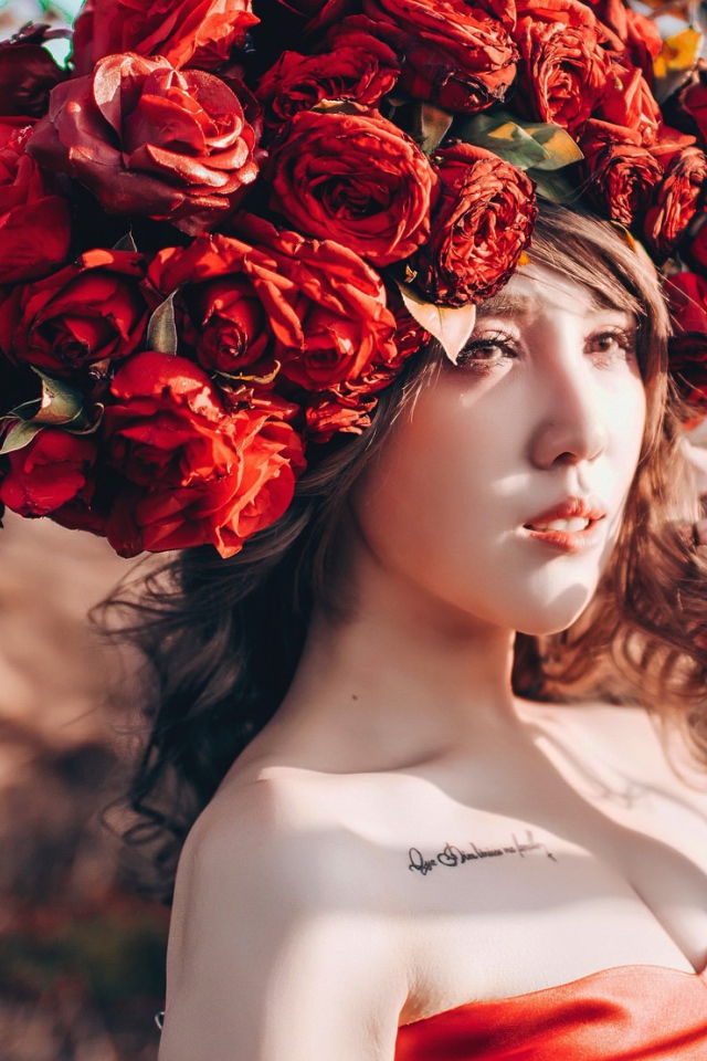 Молодая девушка азиатка с красными цветами на голове