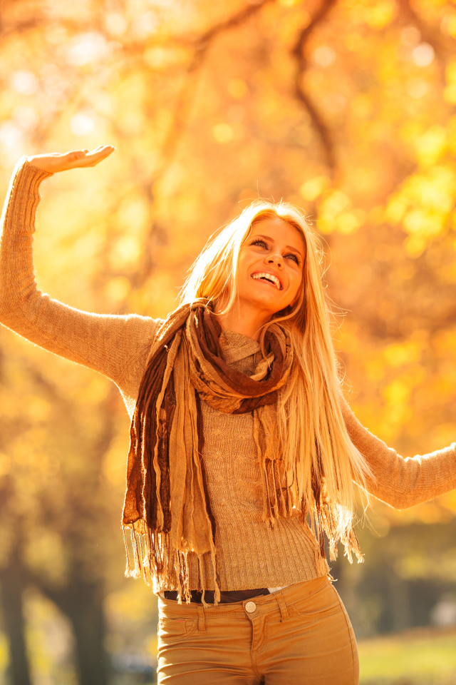 Молодая красивая девушка радуется теплому осеннему солнцу