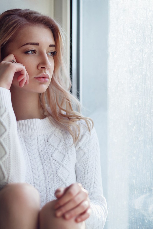 Молодая девушка блондинка у окна 