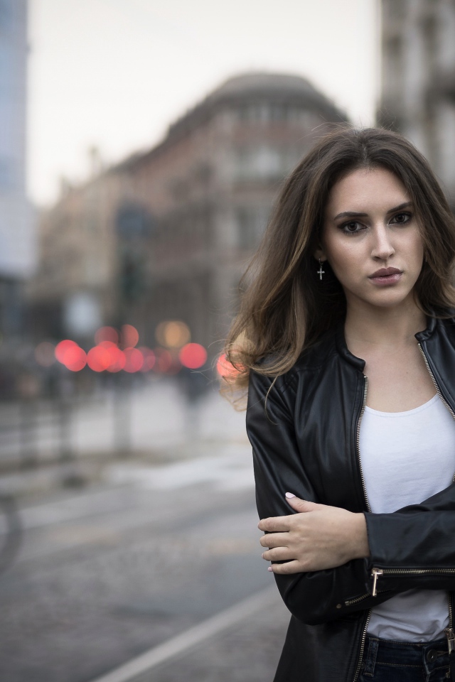 Молодая брюнетка в черной кожаной куртке