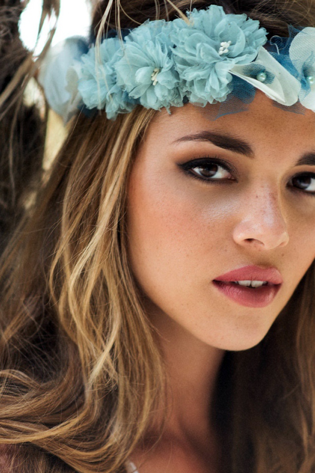 Молодая девушка модель с венком из голубых цветов на голове 