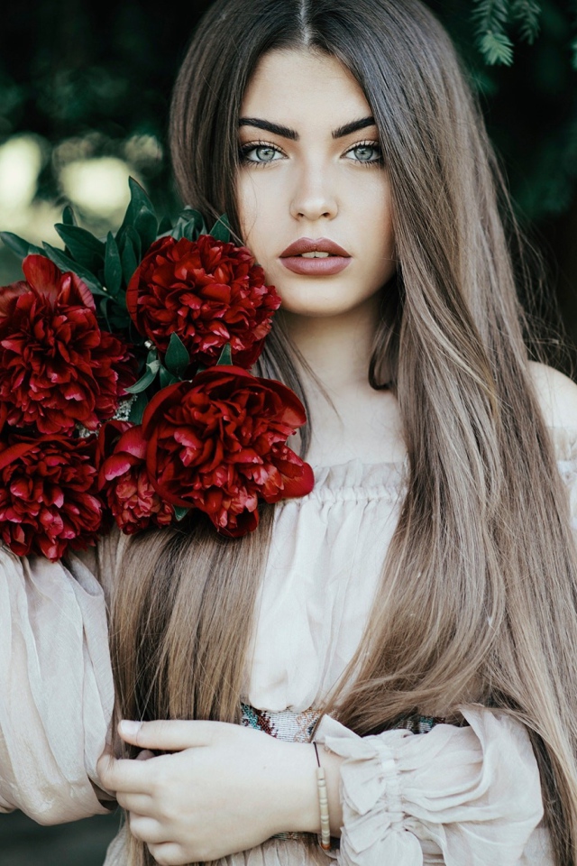 Молодая девушка с букетом бордовых пионов 