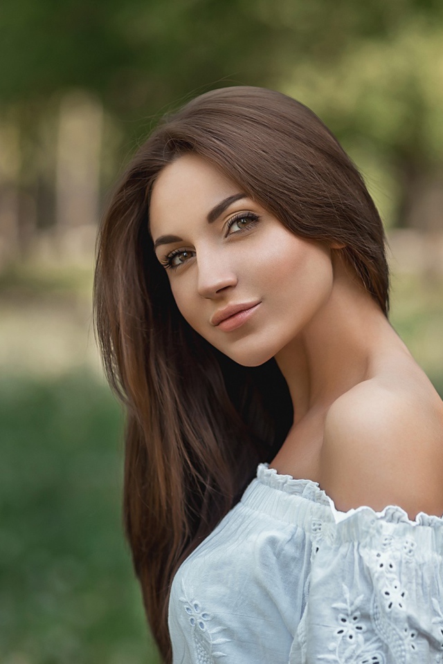 Молодая девушка с длинными волосами в белом 