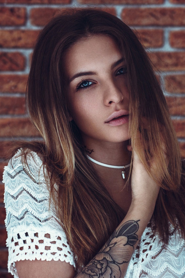 Молодая девушка с татуировкой на руке