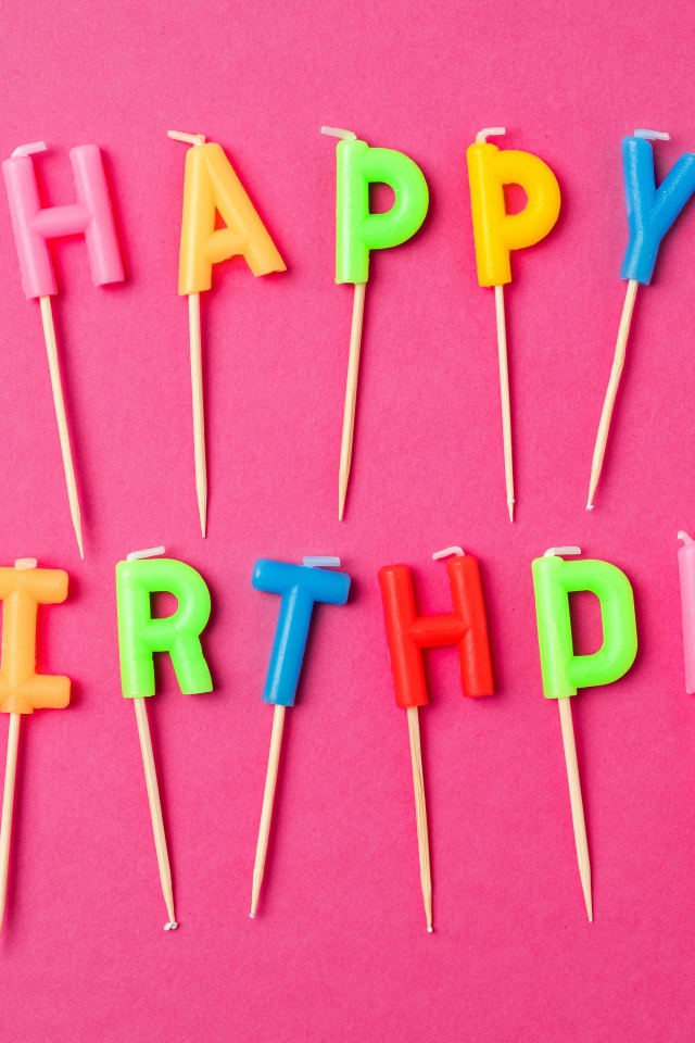 Праздничные свечи с надписью Happy Birthday на розовом фоне